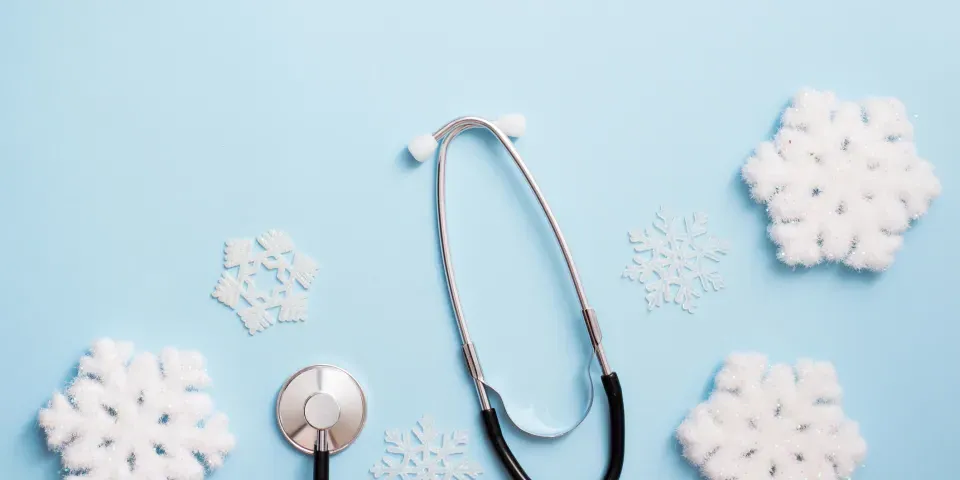 blue background with stethoscope and snowflakes, medical winter holiday. copy space